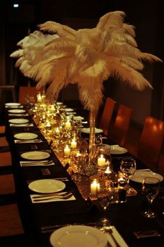 the table is set with candles, plates and place settings for an elegant dinner party