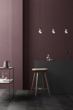 a kitchen with purple walls and wooden stools