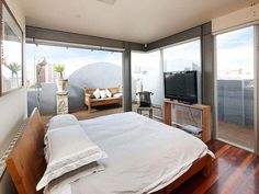 a bedroom with a bed, television and sliding glass doors