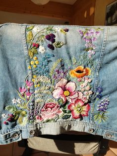 an embroidered jean jacket with flowers on it