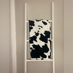 a cow print towel hanging on a ladder