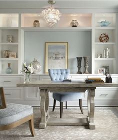 a home office with white cabinets and blue chairs