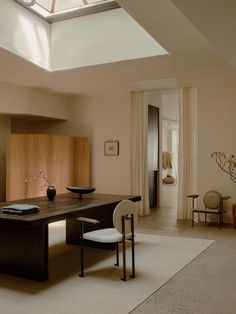 a dining room with a skylight above the table and chairs in front of it