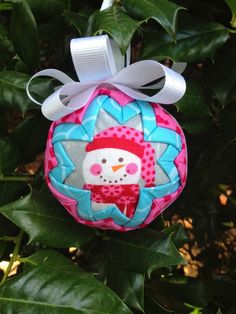 a snowman ornament hanging from a tree