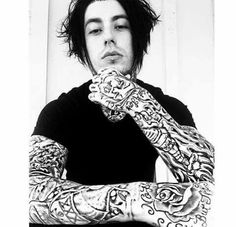 a man with tattoos on his arms posing for the camera