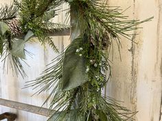 an evergreen wreath hanging on the side of a building