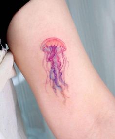 a small jellyfish tattoo on the arm