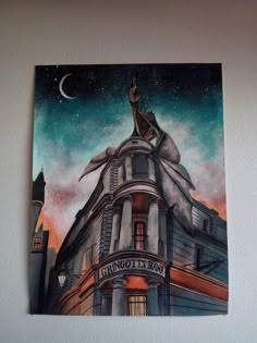 a painting on the wall of a building with a woman sitting on top of it