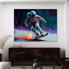 a painting of an astronaut riding a snowboard on a wall above a dresser in a living room