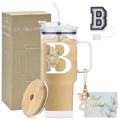 a glass tumbler with a wooden lid and keychain is next to a cardboard box