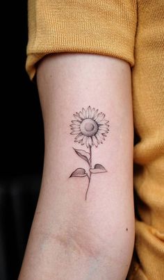 a small sunflower tattoo on the arm