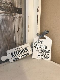 two kitchen signs sitting on top of a counter