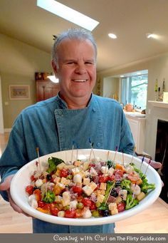 a man holding a platter of food with toothpicks in it