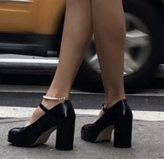 a woman in high heels is standing on the street