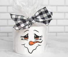 a close up of a candy jar with a face painted on the side and a bow