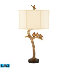 a lamp that has birds on it and a bird sitting on top of the branch