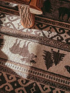 a wooden bench sitting on top of a rug