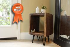 a small wooden shelf sitting next to a mirror on top of a hard wood floor