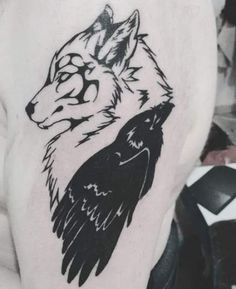 a man with a wolf and bird tattoo on his arm