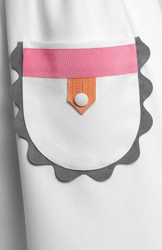 the back of a woman's white shirt with an orange and pink patch on it