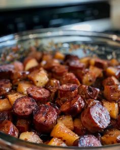 a glass bowl filled with cooked potatoes on top of a table