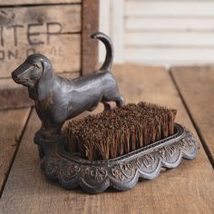 a metal dog brush sitting on top of a wooden table