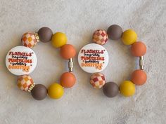 two bracelets with orange, brown and white beads on them that say it's thanksgiving