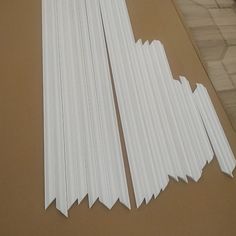 several pieces of white paper sitting on top of a cardboard box next to each other