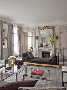 a living room filled with black furniture and white walls