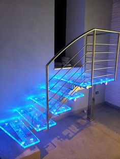 a stair case with blue lights on the bottom and handrails in an empty room