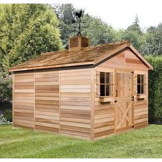 a large wooden shed sitting on top of a lush green field