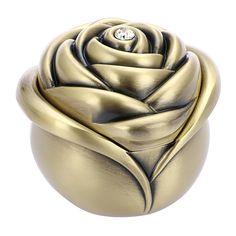 a gold rose shaped box with a diamond in the center