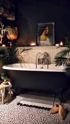 a bathroom with a bathtub and potted plants on the floor next to it