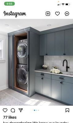 a washer and dryer are in the middle of a kitchen with blue cabinets