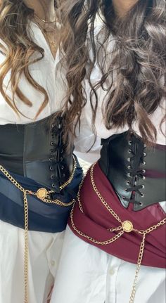 two women wearing corsets with chains on them