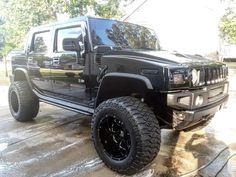 a black hummer is parked in the driveway