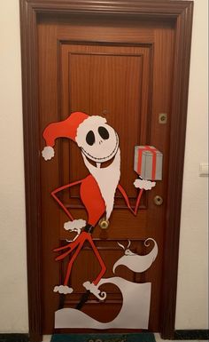 a door decorated to look like santa clause with an elf hat and holding a present