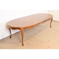 a wooden table sitting on top of a cement floor next to a white brick wall