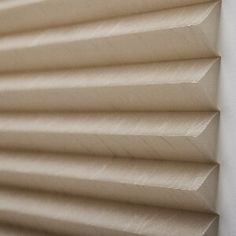 a close up view of the top of a window with pleated shades on it