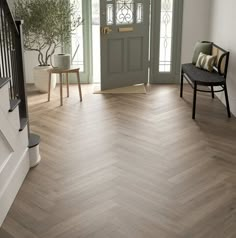 an entryway with wood flooring and green door leading up to the front door