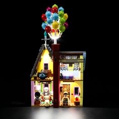 a lego house is lit up with balloons