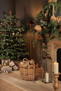 a fireplace mantel with christmas trees and presents on it next to a lit candle