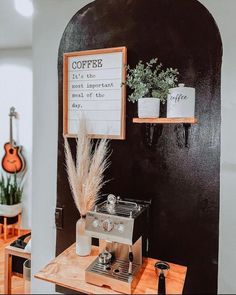 a coffee machine sitting on top of a wooden table next to a sign that says coffee