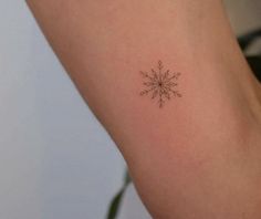 a small snowflake tattoo on the arm