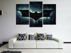 three panels of batman artwork on the wall in a living room with white couches