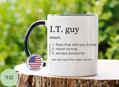 a coffee mug with the words i t guy on it sitting on top of a tree stump