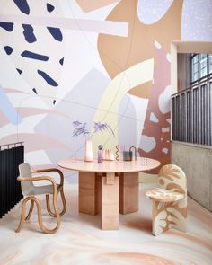 the interior of a modern dining room with an abstract wallpaper and wooden chairs in front of it