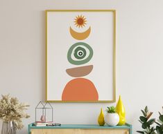 an art print hangs on the wall next to a green cabinet and potted plant