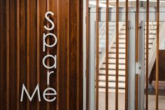 there is a wooden sign that says score me on the side of a building next to some stairs