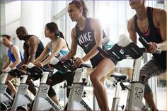 there are many people riding stationary bikes in the gym